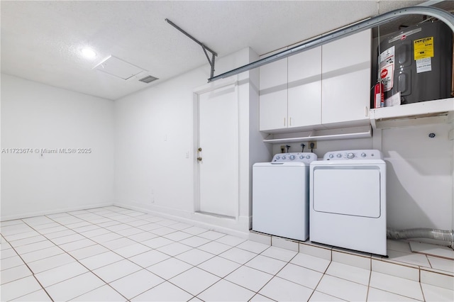 laundry area with light tile patterned floors, a textured ceiling, and washing machine and clothes dryer