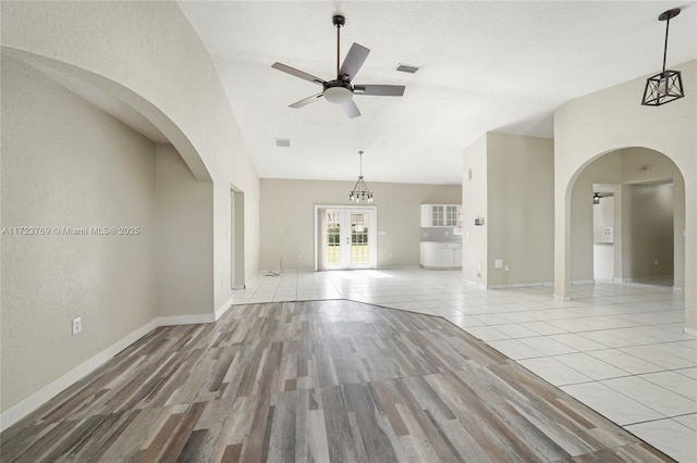 unfurnished living room featuring light hardwood / wood-style floors, french doors, and ceiling fan