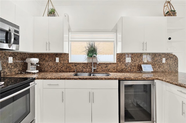 kitchen with stainless steel appliances, white cabinetry, wine cooler, and sink