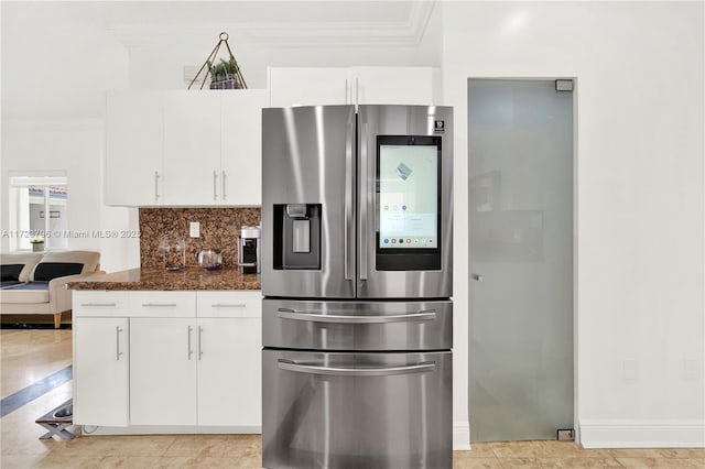 kitchen with white cabinets, stainless steel refrigerator with ice dispenser, dark stone counters, decorative backsplash, and ornamental molding