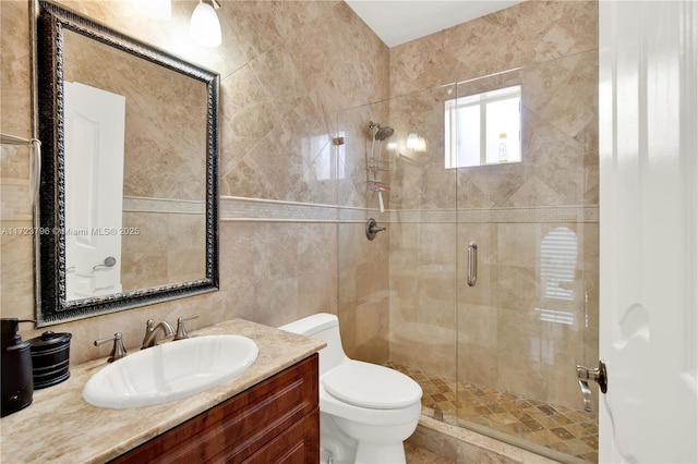 bathroom featuring tile walls, toilet, vanity, and an enclosed shower