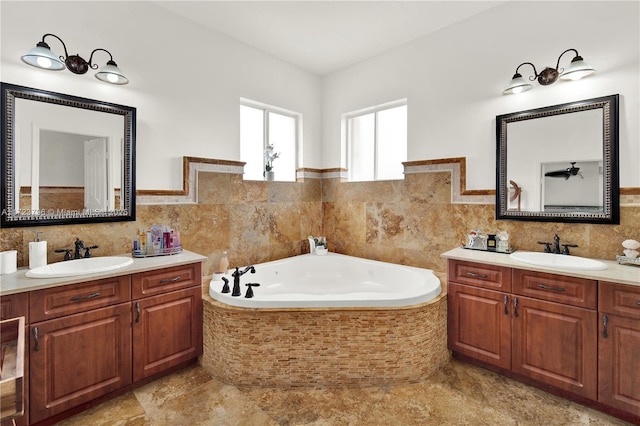 bathroom with vanity, tile walls, and a relaxing tiled tub