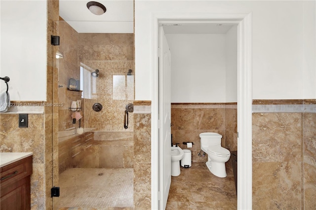 bathroom featuring toilet, vanity, tile walls, a bidet, and a shower with door