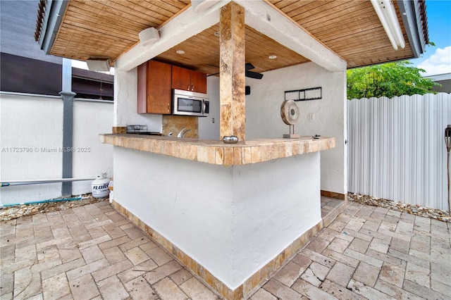 kitchen featuring wood ceiling, kitchen peninsula, and beamed ceiling