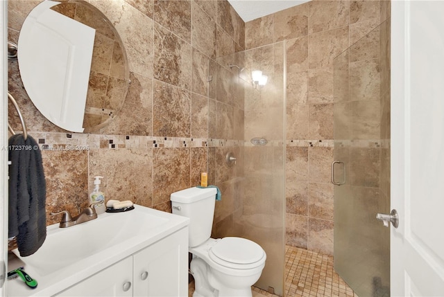 bathroom featuring toilet, vanity, tile walls, and a shower with door