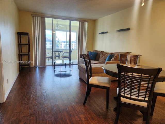 dining space featuring ceiling fan, a wall of windows, and dark wood-type flooring