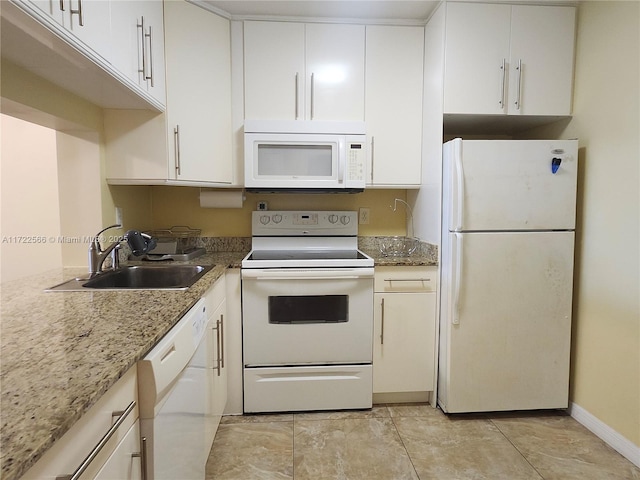 kitchen with white cabinets, white appliances, stone countertops, and sink