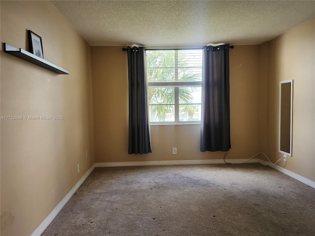 carpeted spare room with a textured ceiling