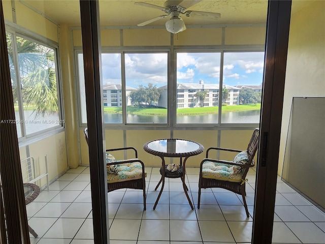 sunroom featuring a wealth of natural light, a water view, and ceiling fan