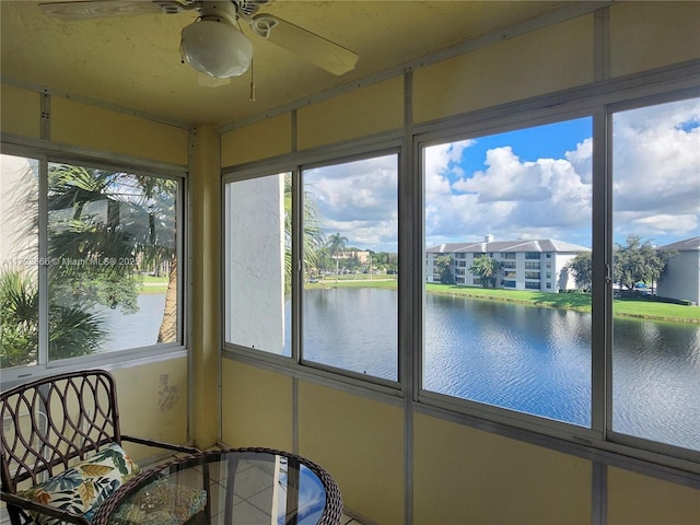 unfurnished sunroom with ceiling fan, plenty of natural light, and a water view