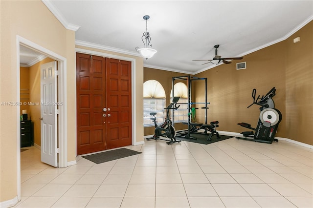 exercise room featuring ceiling fan, light tile patterned floors, and ornamental molding