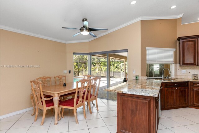 tiled dining room featuring crown molding, sink, and ceiling fan