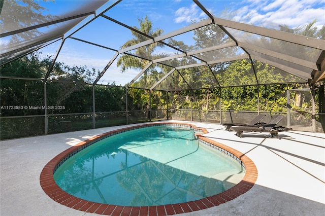 view of swimming pool with glass enclosure and a patio