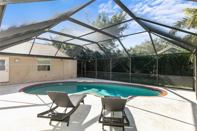 view of swimming pool with glass enclosure and a patio area