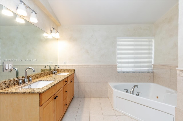 bathroom featuring a tub to relax in, tile patterned flooring, vanity, and tile walls