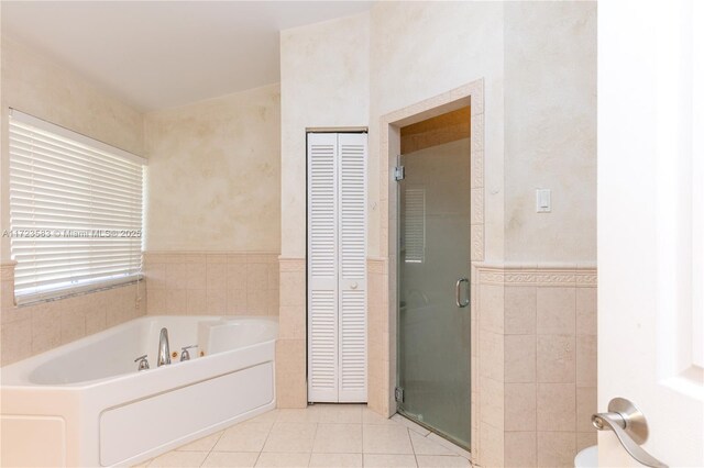 bathroom with tile patterned floors, independent shower and bath, and tile walls