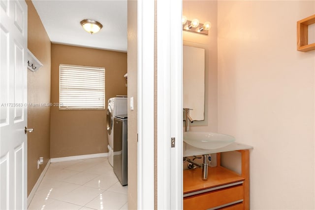 laundry area with separate washer and dryer, sink, and light tile patterned floors