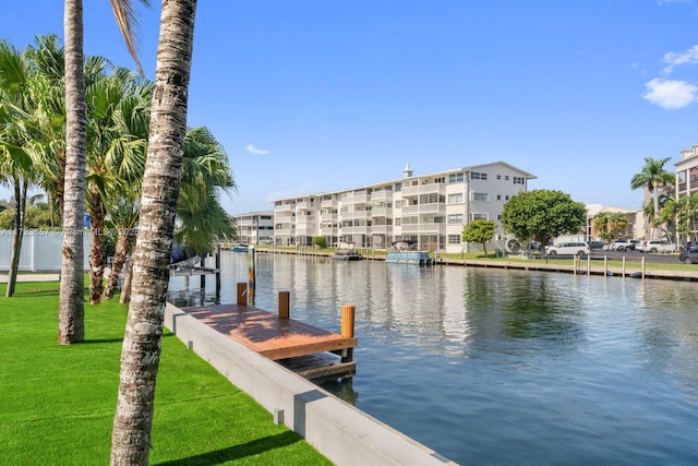 view of dock with a water view and a yard