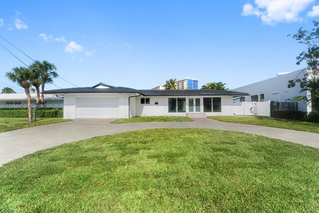 ranch-style home featuring a garage and a front lawn