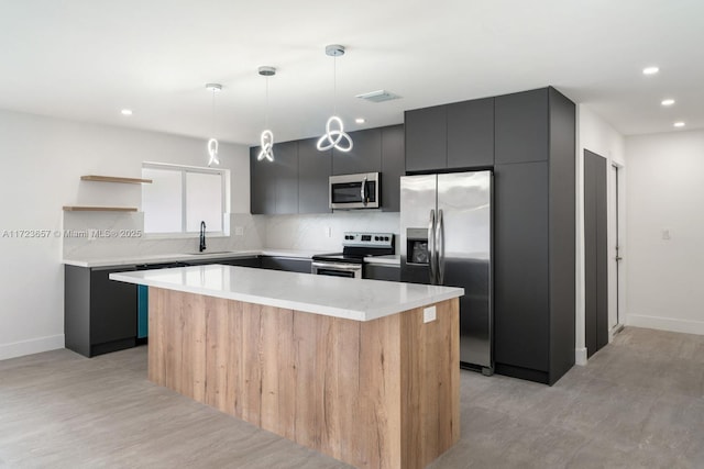 kitchen featuring hanging light fixtures, sink, a center island, and appliances with stainless steel finishes