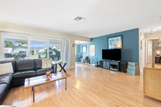 living room featuring wood-type flooring and a textured ceiling