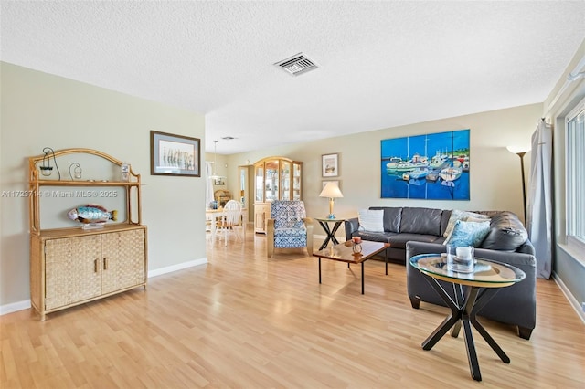 living room featuring a textured ceiling and light wood-type flooring