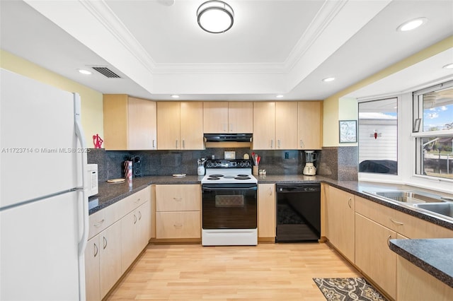 kitchen with a tray ceiling, light brown cabinets, and white appliances