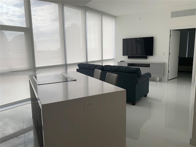 tiled living room with floor to ceiling windows and plenty of natural light