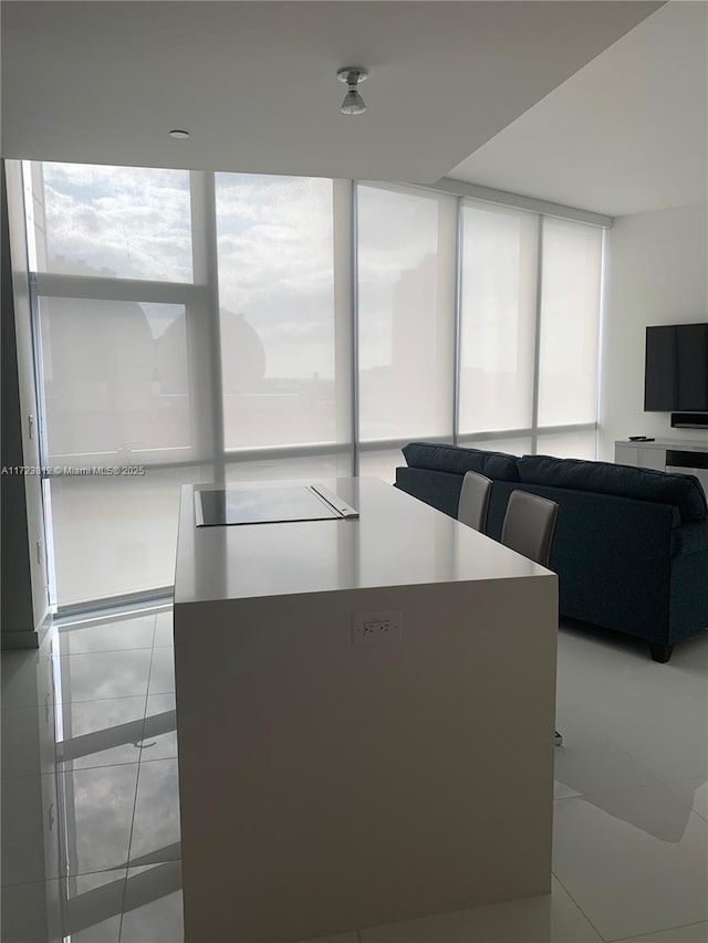 living room with floor to ceiling windows and light tile patterned flooring