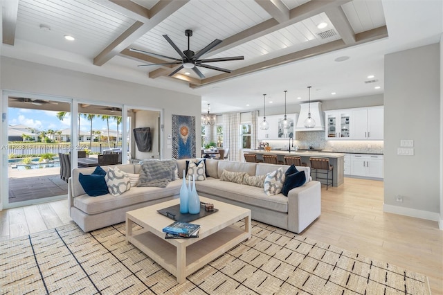 living room with beamed ceiling, sink, ceiling fan, wooden ceiling, and light hardwood / wood-style flooring