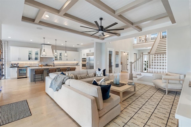 living room featuring beverage cooler, light hardwood / wood-style floors, ceiling fan, wooden ceiling, and beam ceiling