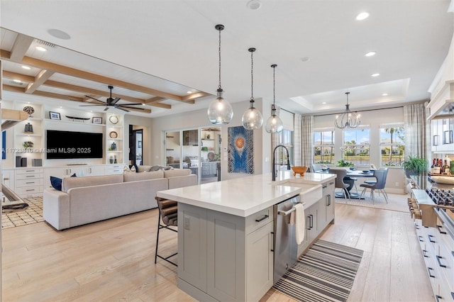 kitchen featuring ceiling fan with notable chandelier, a spacious island, decorative light fixtures, beamed ceiling, and a breakfast bar area