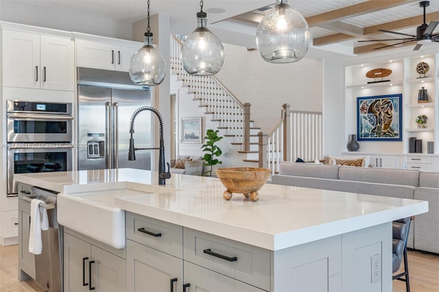 kitchen featuring light wood-type flooring, a kitchen island, stainless steel appliances, and a kitchen bar