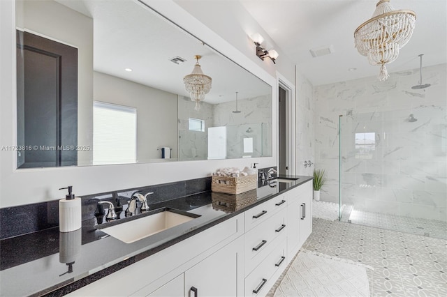 bathroom featuring vanity, an inviting chandelier, and tiled shower