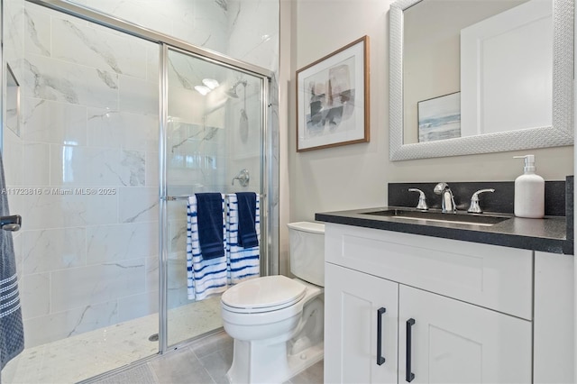 bathroom with an enclosed shower, vanity, tile patterned floors, and toilet