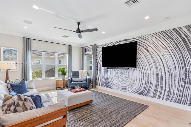 living room featuring ceiling fan, ornamental molding, and hardwood / wood-style floors