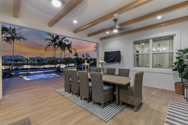 dining area with beamed ceiling and light wood-type flooring