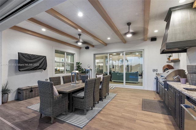 dining area featuring ceiling fan, beamed ceiling, and light wood-type flooring