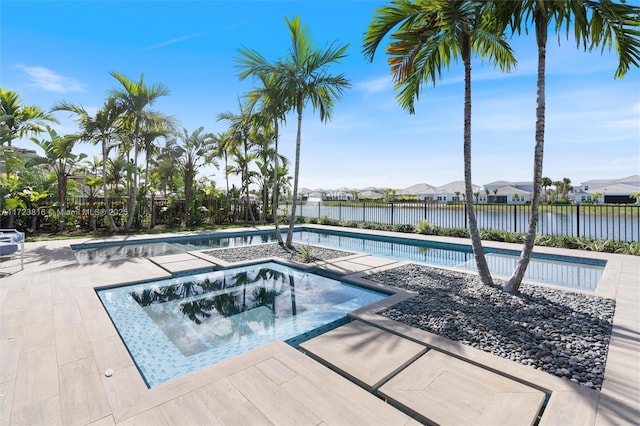 view of pool featuring a water view and an in ground hot tub