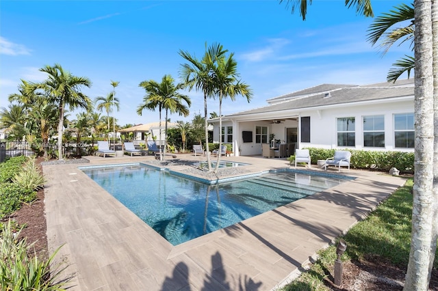 view of pool featuring ceiling fan, a jacuzzi, and a patio area