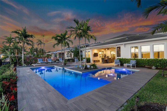 view of swimming pool featuring ceiling fan and a patio