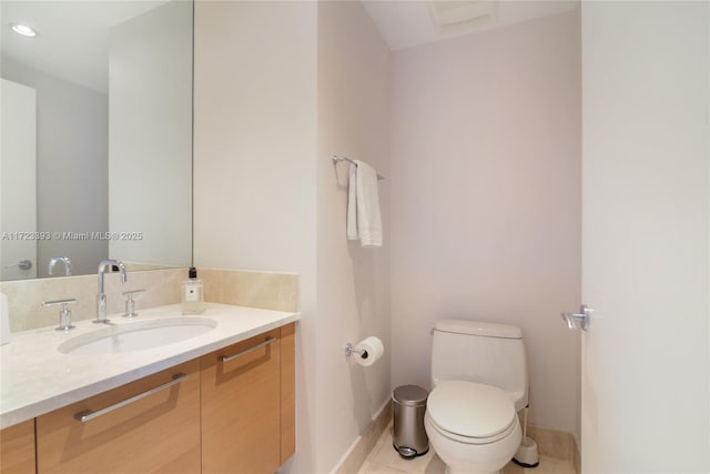 bathroom with tile patterned flooring, vanity, and toilet