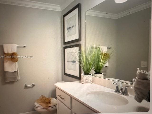 bathroom featuring crown molding, vanity, and toilet