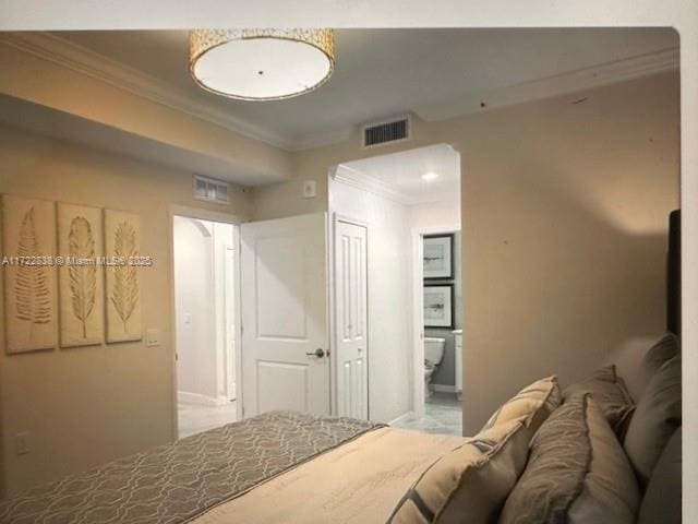 bedroom with ensuite bath and crown molding