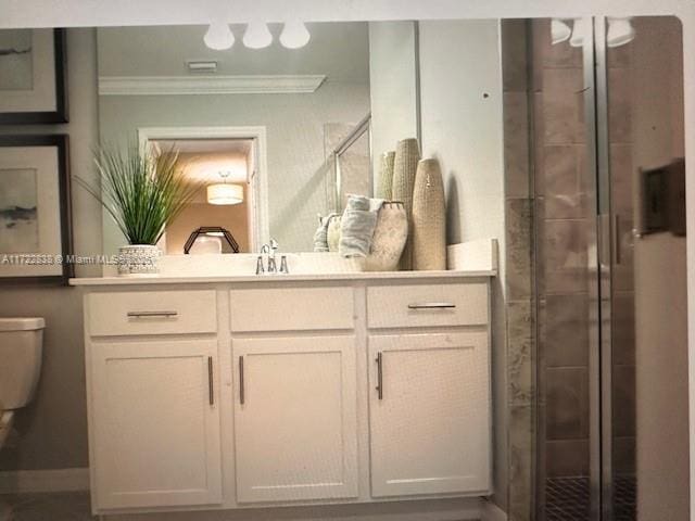 bathroom featuring ornamental molding, vanity, a shower with shower door, and toilet