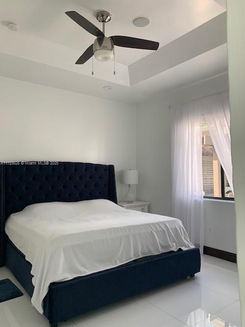 bedroom with a tray ceiling and ceiling fan