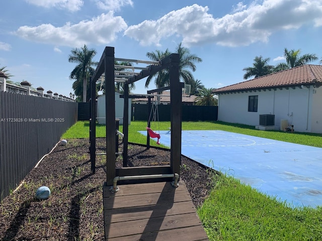 view of yard with central AC unit and basketball court