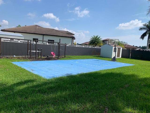 view of yard with a storage unit and basketball court