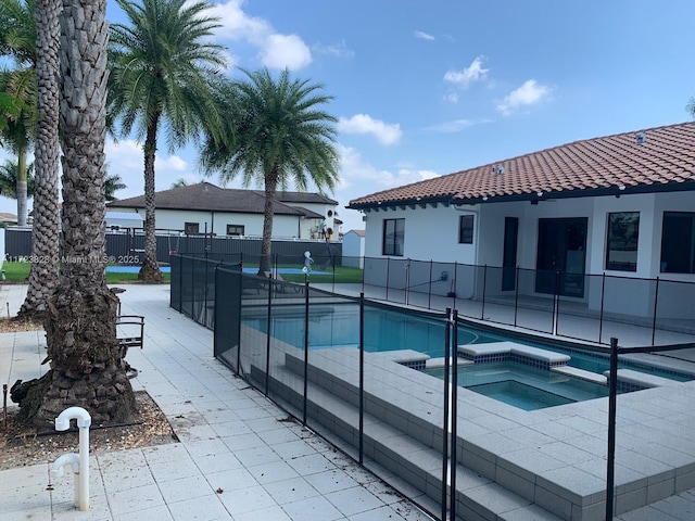 view of swimming pool featuring an in ground hot tub and a patio