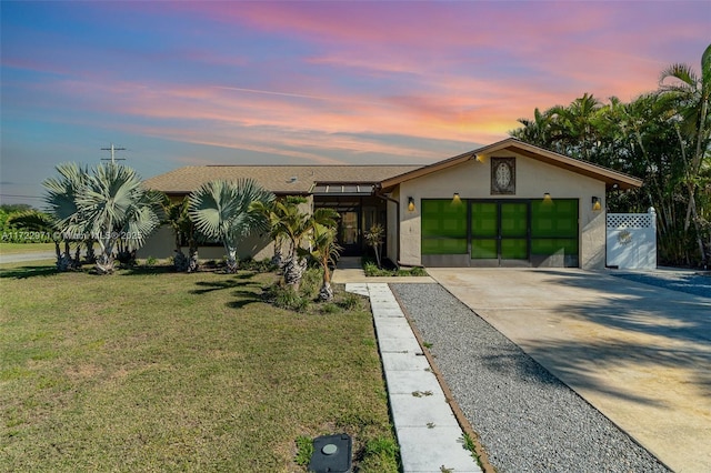 view of front of property featuring a garage and a yard